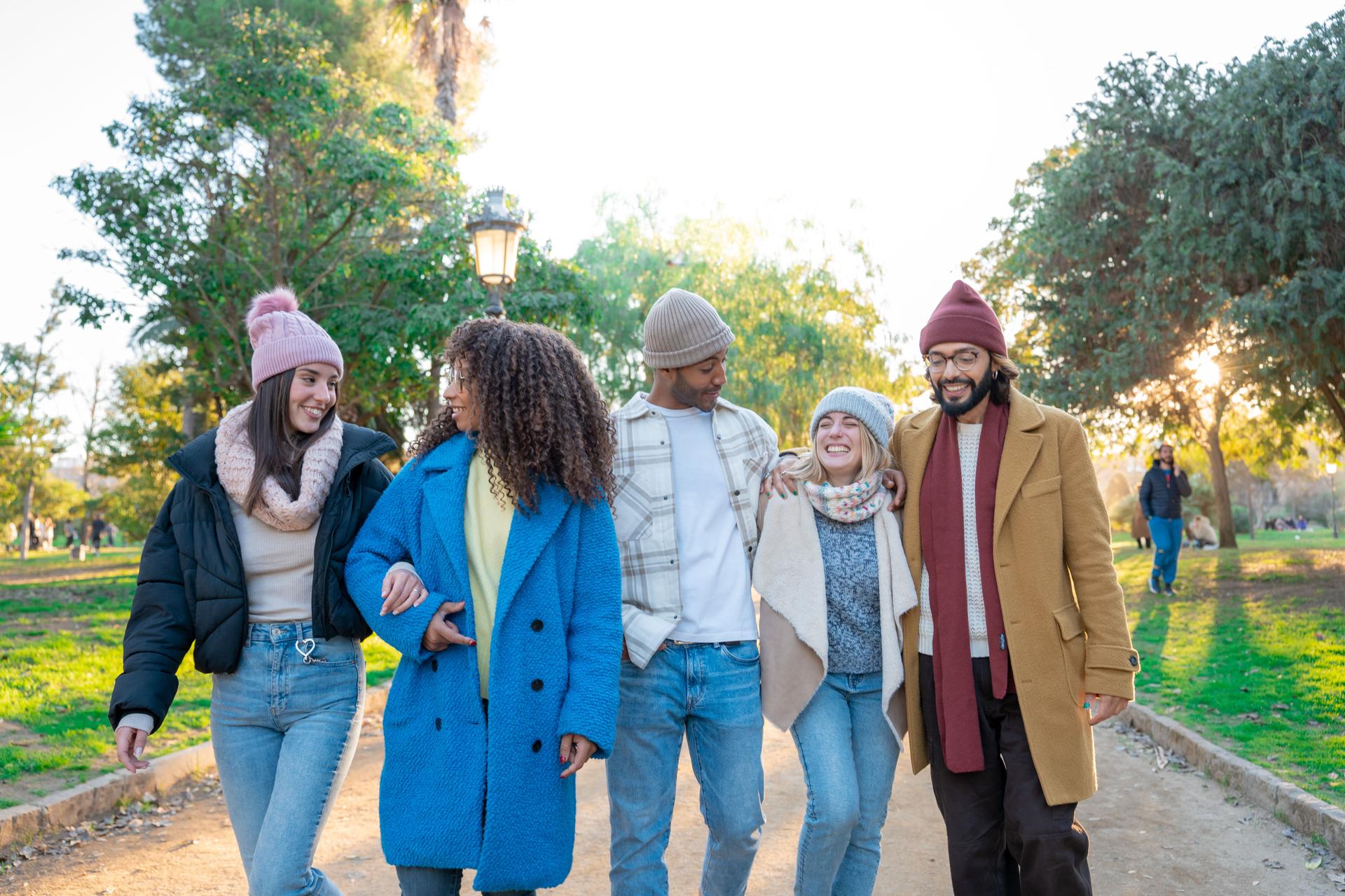 Cheerful group of students walking outdoors in the campus University college having fun together.